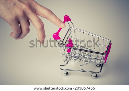 beautiful pink shopping cart in woman hand with white background - shopping concept