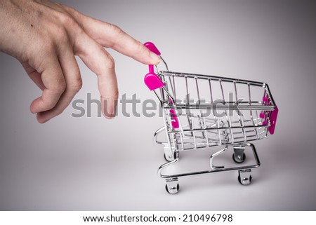 beautiful pink shopping cart in woman hand with white background - shopping concept