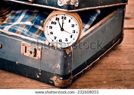 Old suitcase with old alarm clock and old shirt