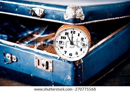 Old suitcase with old alarm clock and old shirt