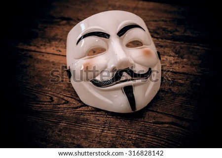 white anonymous mask on wood background - retro style