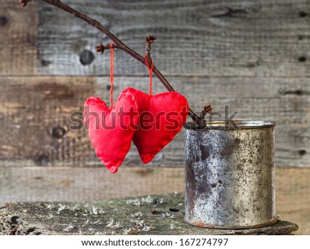 Two hearts on a twig on the board in rusty tin