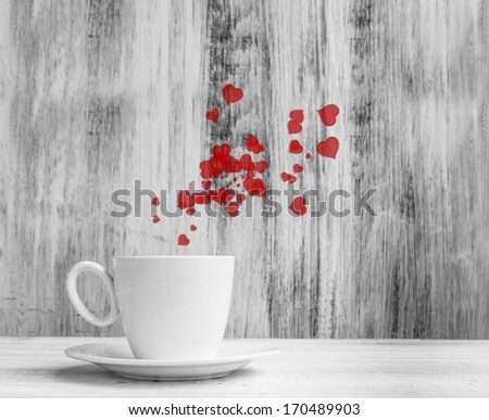 Mug for lovers. White cup full of warm hearts on a wooden background.