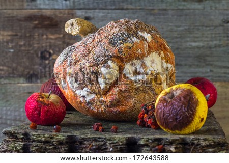 Old and rotten fruit on wooden board