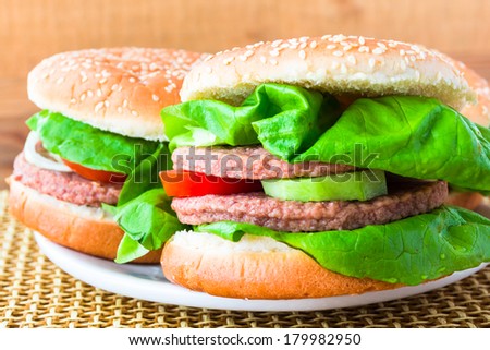 Two homemade grilled hamburger on wooden mat