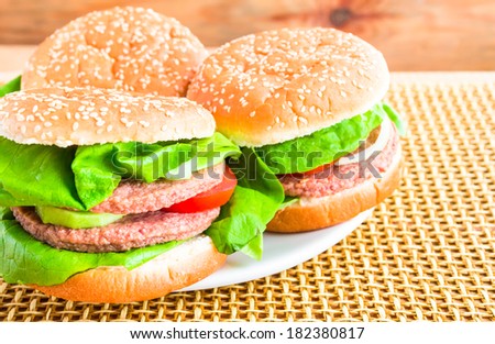 plate of hamburgers on a wooden mat