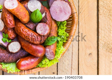 Background with a basket full of meat, sausages and different meats