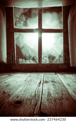 Old rural interior: a window table overlooking the blurry lights. Space for text or product