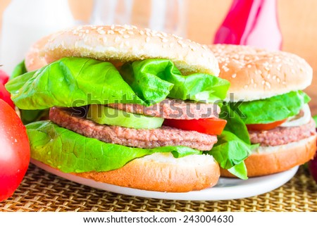 Two homemade grilled hamburger on wooden mat