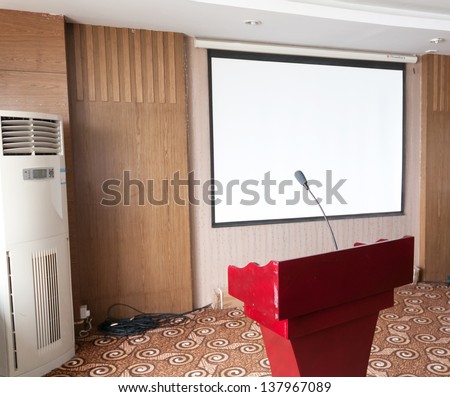 Photo of empty conference room with microphones and blank