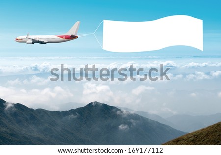 An airplane flying through the sky pulling a blank white banner to add your own message.