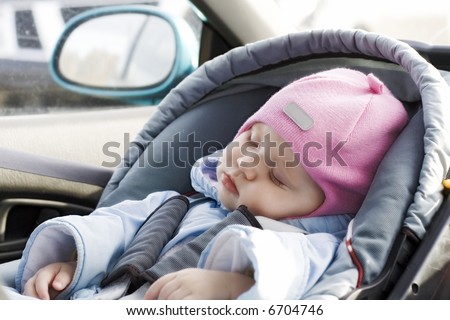 Little baby sleeping in a car in a child`s car seat