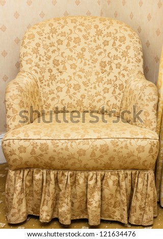 Closeup of empty retro brown armchair with floral pattern.
