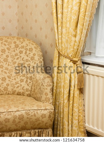 View of brown vintage armchair near retro curtain.