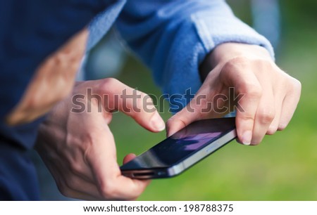 Woman hands holding black smartphone and tapping screen