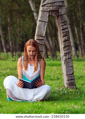 Beautiful woman reading a book in park