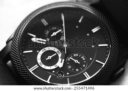 Elegant casual brown watch on green background. Black and white photo.