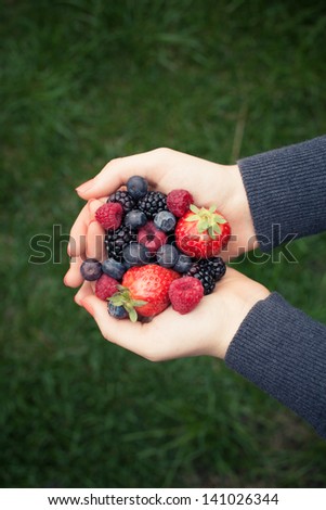 Hands holding red fruit