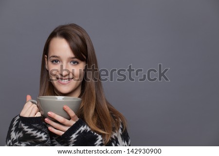 Portrait of a cute young lady in the winter with a cup of tea.