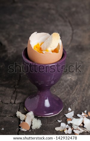 Boiled egg in an eggcup on wooden background