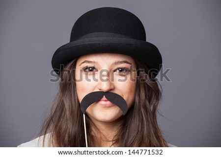 Pretty girl with hat and a paper mustache