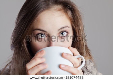 Portrait of a cute young lady in the winter with a cup of tea.