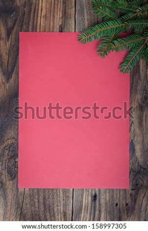 Pine tree with empty paper sheet on old wooden background