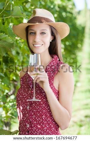 Happy young woman holding a glass of red wine