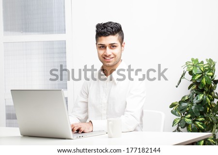 Young Asian Indian Businessman working on laptop in office