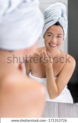 Attractive middle aged woman looking in the mirror