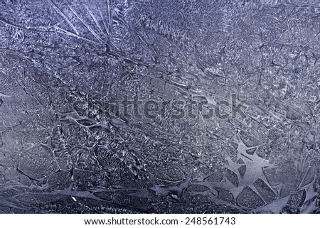 Close view of an abstract pattern resembling cracked and shattered ice on a dark background