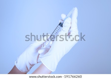 Hand holding Syringe and medicaments, used color filter on flash