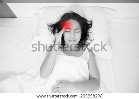 woman lying in bed with headache, migraine, stress, insomnia, hangover with red alert accent