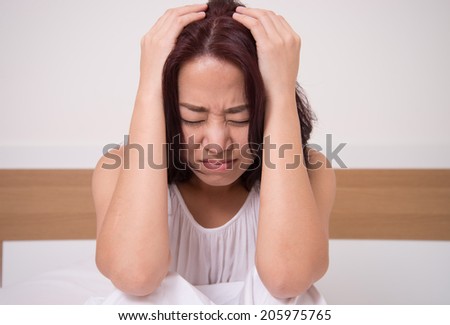 woman with headache, migraine, stress in bedroom