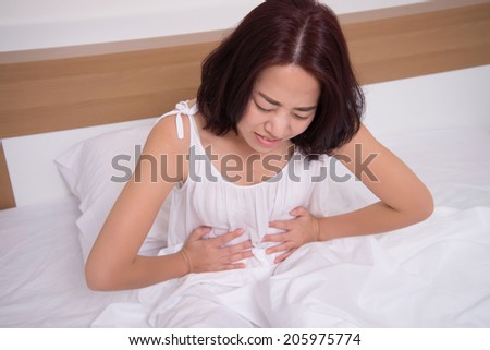 sick woman on bed concept of stomachache