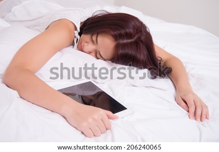 woman in bed holding tablet sleeping