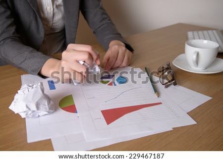 Stressed business woman with stack of paperwork