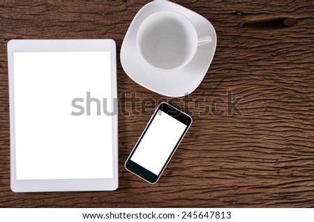 Digital tablet computer and smart phone with isolated screens on wood background