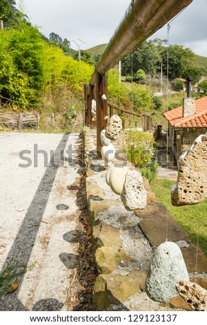Natural wooden railing with decorative hanged stones