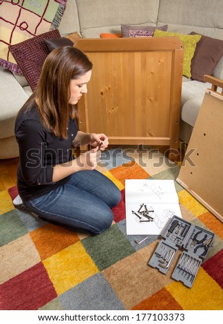 Girl with tools and instructions ready to assemble a new furniture for home