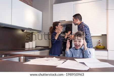 Sad child suffering and his parents having hard discussion in a home kitchen by couple difficulties. Family problems concept.