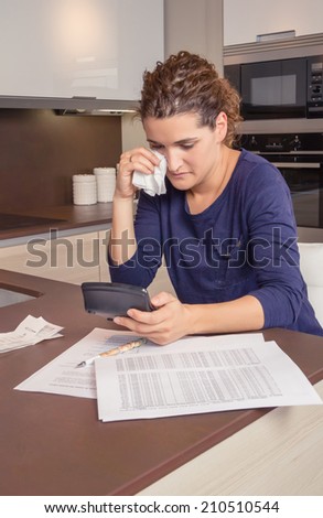 Unemployed and divorced woman with many debts reviewing her monthly bills