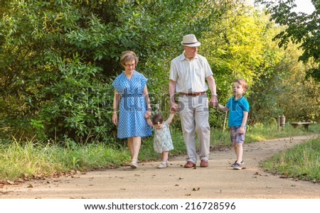 Front view of grandparents and grandchildren walking on a nature path