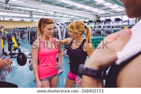 Personal trainer encouraging to sad young woman after a hard training day in the gym