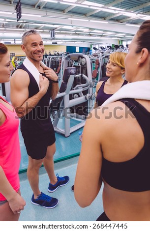 Group of women friends talking with personal trainer of a fitness center after hard training day