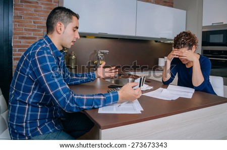 Desperate and unemployed young couple reviewing their credit card debts. Financial family problems concept.