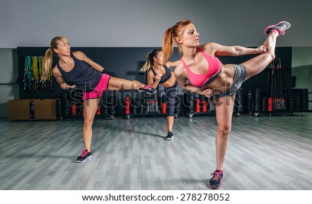 Group of beautiful women in a hard boxing class on gym training high kick