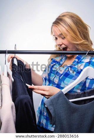 Portrait of happy girl teenager looking a big offer in clothes indoors. Sales discount concept.