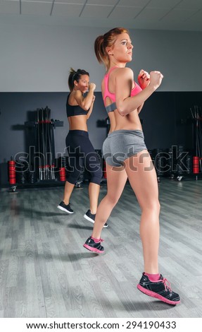Group of beautiful women jumping in a hard boxing training on gym