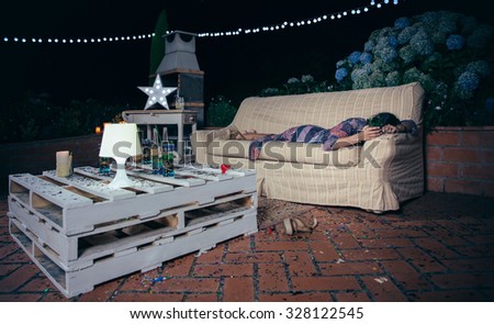 Lonely drunk woman holding glass and sleeping lying over a sofa after outdoors party. Fun and alcohol and drugs problems concept.